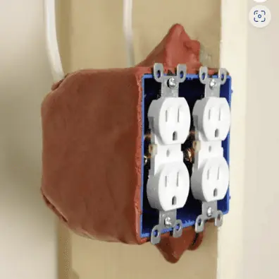 Putty pad installed around an electrical outlet box.