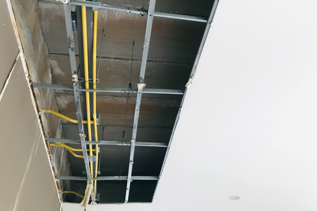 Image of a Dropped ceiling. The grid is apparent and the grid supports drywall.